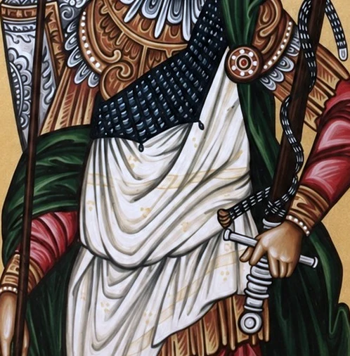 Fragment ikone Svetog Dimitrija — ornament oklopa, pletena košulja, balčak mača u šaci i nabori bele tkanine.
